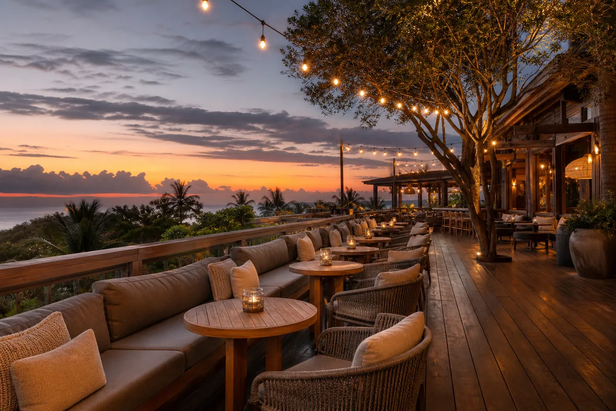 Terrasse de restaurant aménagée avec assises confortables et tables rondes, ambiance soirée