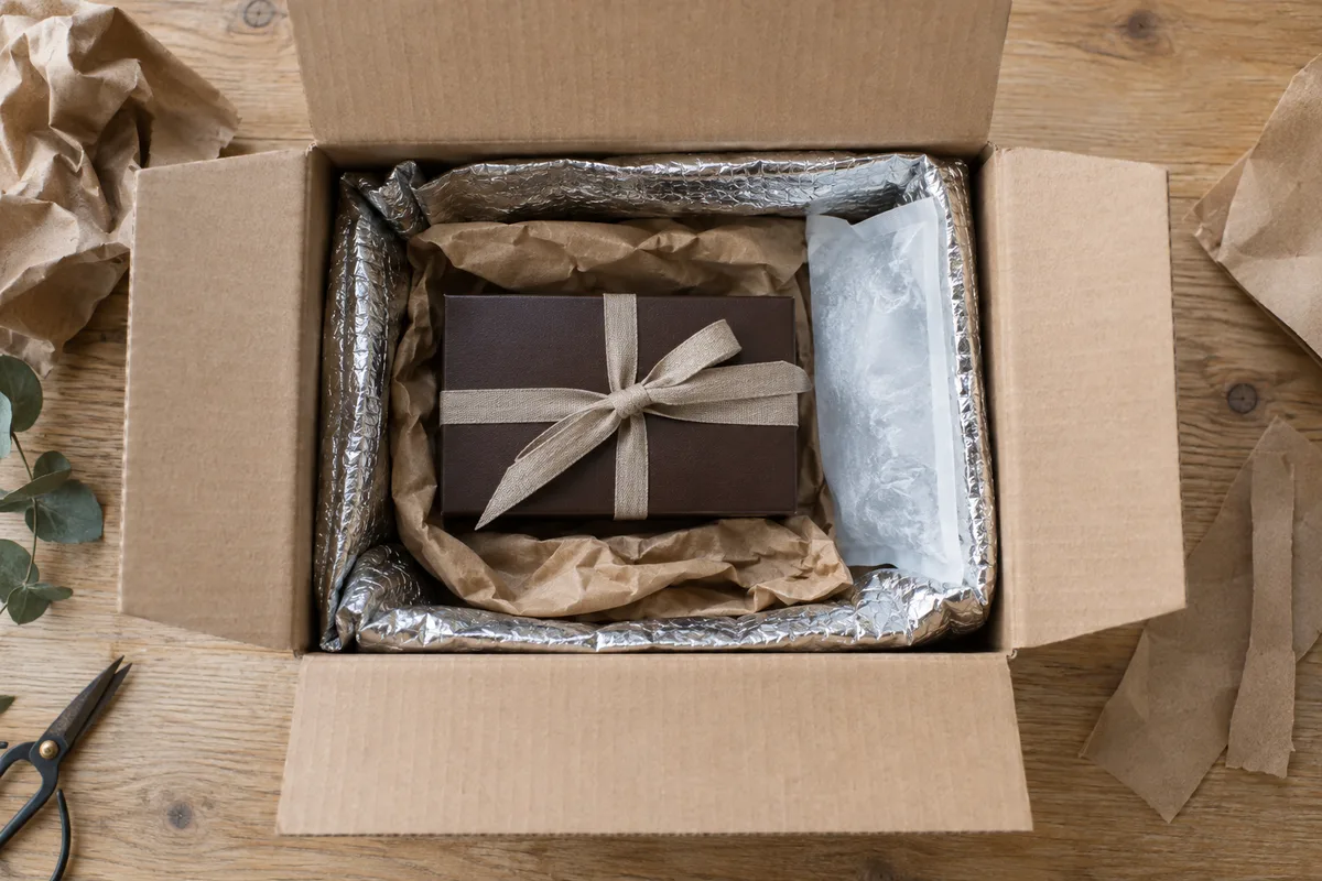 Colis d’expédition ouvert avec poche isotherme, bloc réfrigérant et ballotin de chocolats